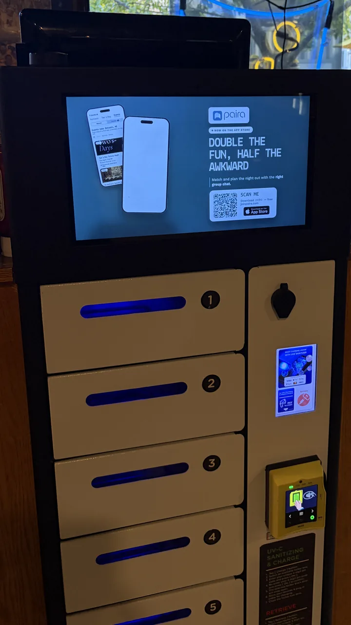 Charging locker at The Brown Jug playing a Paira app ad on its screen