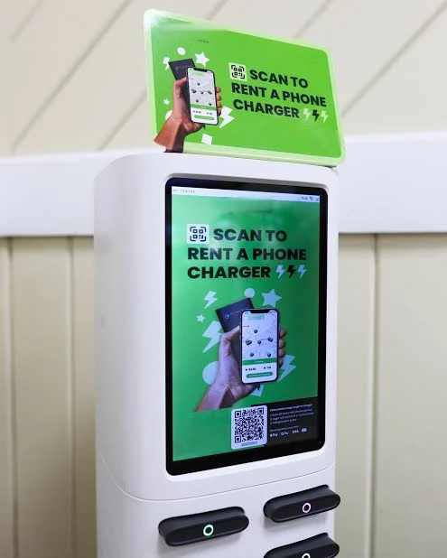 Phone-charger rental kiosk with a large ad screen in a restaurant